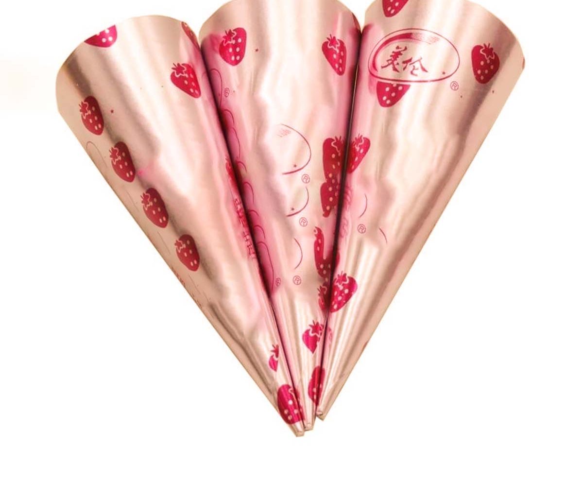 Pink foil cone wrappers printed with a repeating strawberry motif