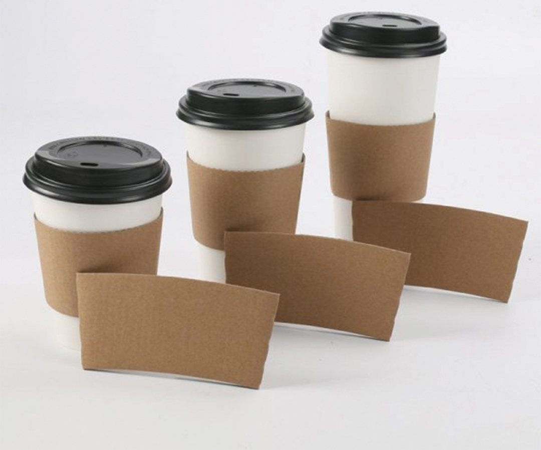 Three takeaway cups beside a stack of flat kraft beverage sleeves