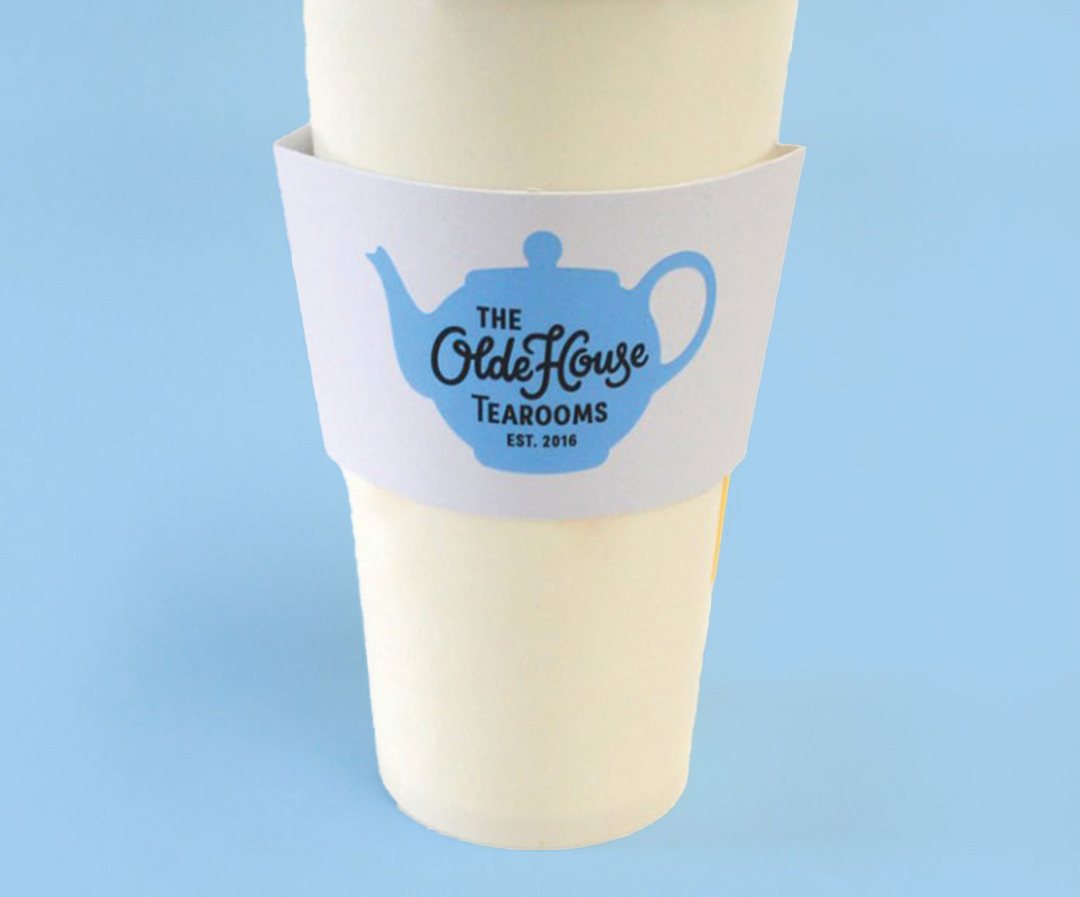 Cold drink cup wearing a printed sleeve for a tearoom brand