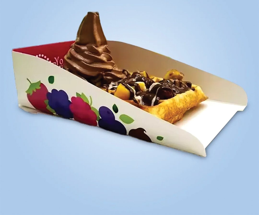 Printed dessert tray holding a soft-serve waffle with fruit and sauce
