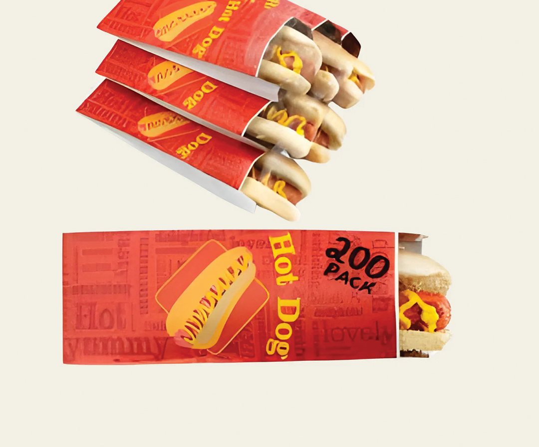 Red printed hot dog sleeves lined up with loaded hot dogs
