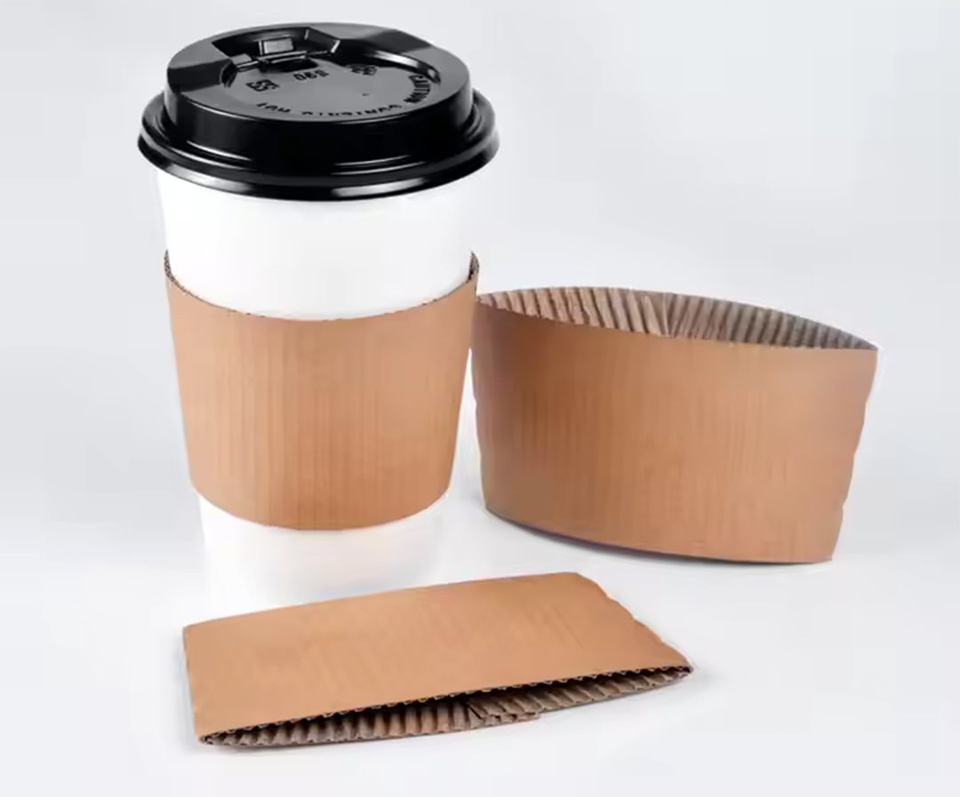 Hot cups fitted with kraft coffee sleeves beside loose flat sleeves