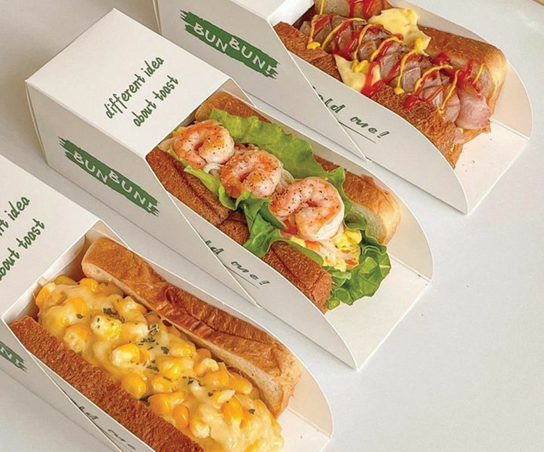 Printed sandwich trays holding filled baguettes in a row
