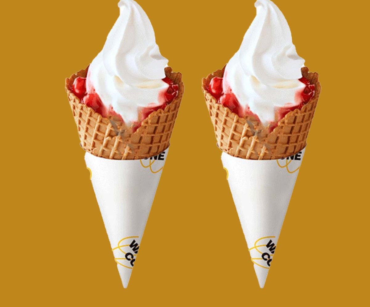 Plain cone sleeves holding soft-serve on an orange backdrop