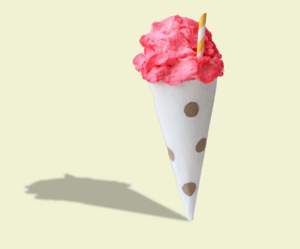 White cone sleeve with gold polka dots holding pink gelato